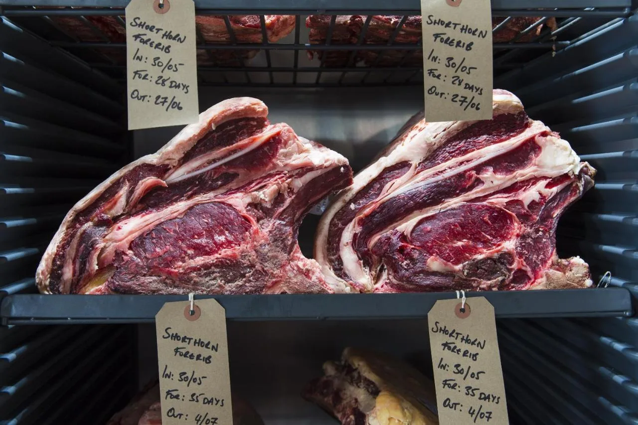 two racks of meat on display in a store at The Porterhouse Grill and Rooms in Oxford